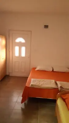a bedroom with an orange bed and a window at Panorama in Čanj