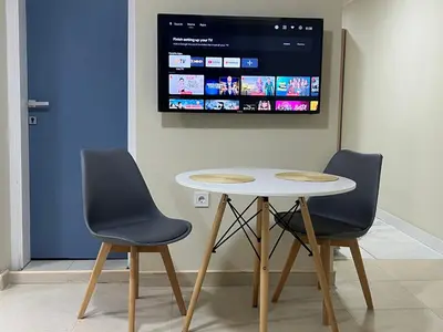 two chairs and a table with a tv on the wall at Lucky center Apartment in Podgorica