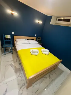 a bedroom with a yellow bed with towels on it at Lucky center Apartment in Podgorica