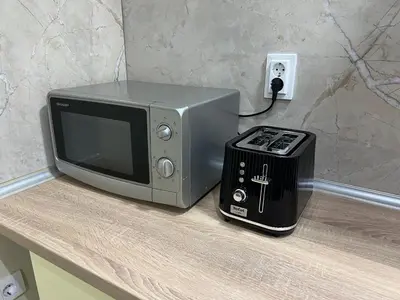 a microwave and a toaster oven on a counter at Lucky center Apartment in Podgorica