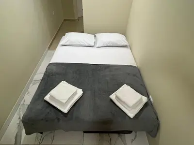 a bed with two pillows on top of it at Lucky center Apartment in Podgorica