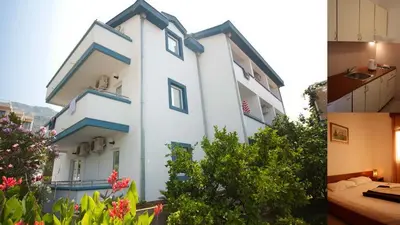 a white building with blue trim next to a bedroom at Apartments Becici in Budva