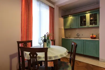 a kitchen with a table and a kitchen with green cabinets at Villa Velzon Guesthouse in Budva
