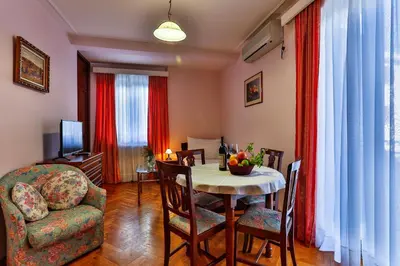 a living room with a dining room table and a chair at Villa Velzon Guesthouse in Budva