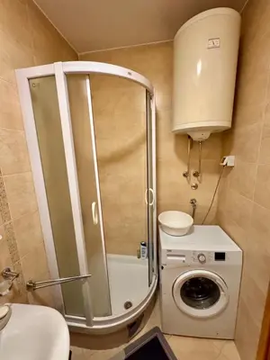 a bathroom with a shower and a washing machine at Apartment Milana in Konik