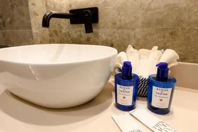 a bathroom counter with a sink and a bowl and towels at Modular Central Studio in Kotor