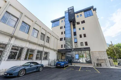 two blue cars parked in a parking lot in front of a building at Modular Central Studio in Kotor