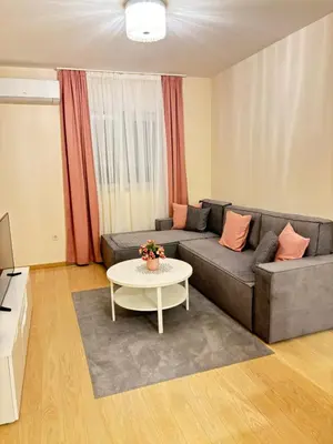a living room with a couch and a table at Apartment Enjoy City kvart in Podgorica