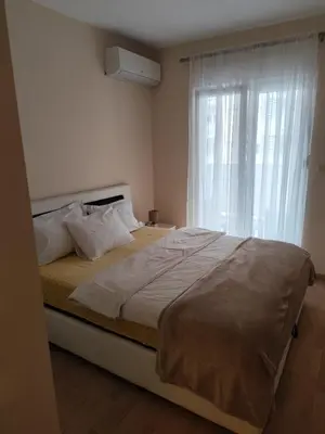 a bedroom with a large bed with a window at Apartment Enjoy City kvart in Podgorica