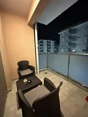 a balcony with two chairs and a table on a building at Apartment Enjoy City kvart in Podgorica