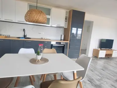a kitchen with a white table and chairs at Suite Madric in Pečurice