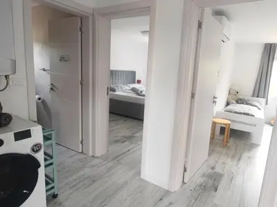 a room with a kitchen and a bedroom with two beds at Suite Madric in Pečurice