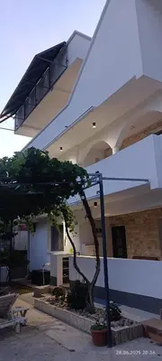 a tree in front of a building with a balcony at Suite Madric in Pečurice