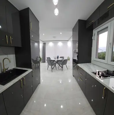 a kitchen with black cabinets and a table with chairs at Sisters residence in Kotor