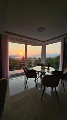 a room with a table and chairs and a large window at Sisters residence in Kotor