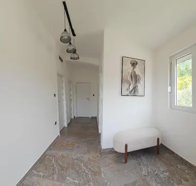 a white hallway with a bench and a window at Sisters residence in Kotor