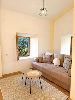 a living room with a couch and a table at Old House Poda in Rap