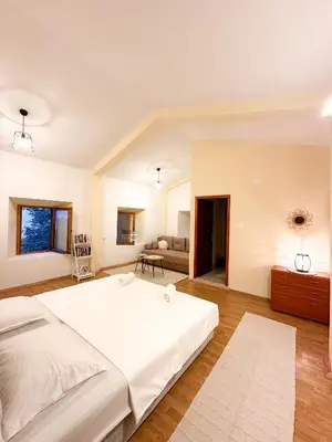 a bedroom with a large white bed and a couch at Old House Poda in Rap
