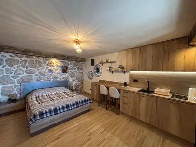 a bedroom with a bed and a stone wall at Old House Poda in Rap