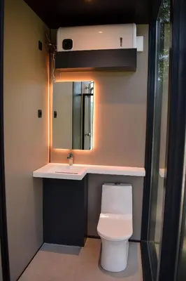 a bathroom with a toilet and a sink and a mirror at Oblun Eco Resort - Mirror Cabin in Podgorica