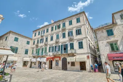 a group of buildings in a street with people walking at Luxury Main Square apartment by MN Property in Kotor
