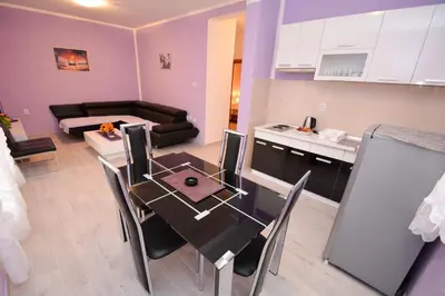 a kitchen and a living room with a dining table at Marinero Apartments in Kotor