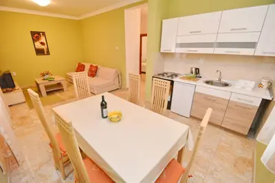 a kitchen and a dining room with a table and a kitchen and a living room at Marinero Apartments in Kotor