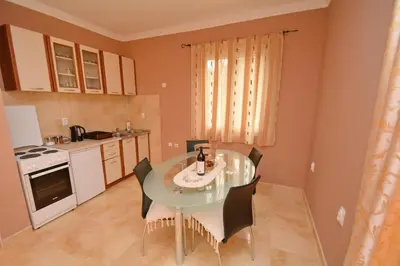 a kitchen with a table and chairs in a room at Marinero Apartments in Kotor