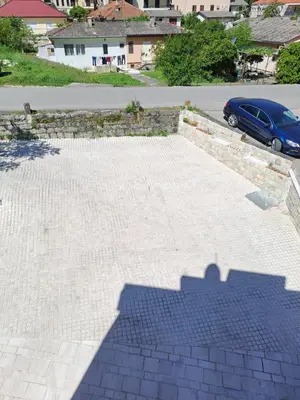 a shadow of a car parked in a parking lot at Marinero Apartments in Kotor