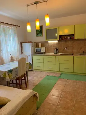 a kitchen with green cabinets and a table with a tableablish at Njaro del mar 3 in Petrovac na Moru