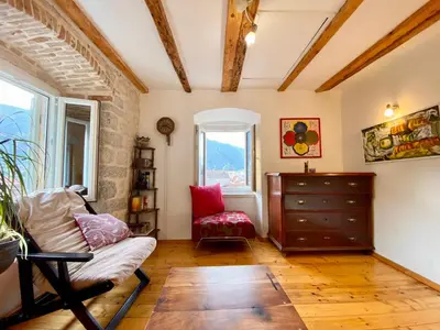 a living room with a chair and a dresser at Charming rooftop view in Kotor