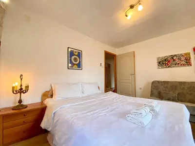 a bedroom with a white bed with towels on it at Charming rooftop view in Kotor