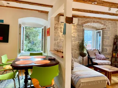 a dining room with a table and green chairs at Charming rooftop view in Kotor