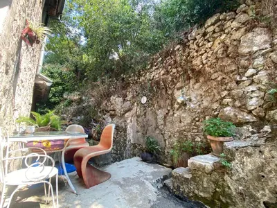 a table and chairs in front of a stone wall at Charming rooftop view in Kotor