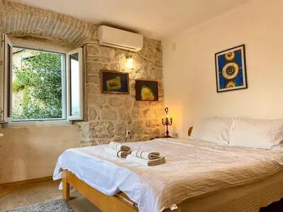 a bedroom with a large bed with a window at Charming rooftop view in Kotor
