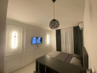 a bedroom with a bed and a tv on the wall at Central Terminal Podgorica in Podgorica