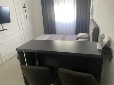 a desk with two chairs in a room with a bed at Central Terminal Podgorica in Podgorica