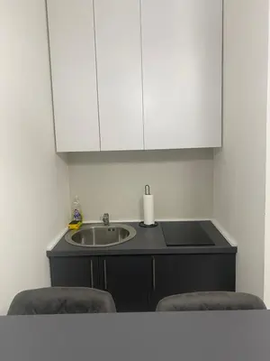 a kitchen with a sink and a counter with two chairs at Central Terminal Podgorica in Podgorica