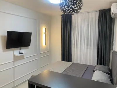 a bedroom with a bed and a tv on a wall at Central Terminal Podgorica in Podgorica