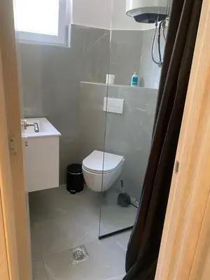 a bathroom with a toilet and a glass shower door at Central Terminal Podgorica in Podgorica