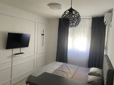 a bedroom with a bed and a flat screen tv at Central Terminal Podgorica in Podgorica