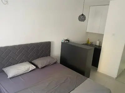 a bed in a small room with a kitchen at Central Terminal Podgorica in Podgorica