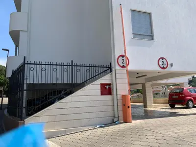 a building with a stairway next to a parking lot at Njaro del mar 1 in Petrovac na Moru