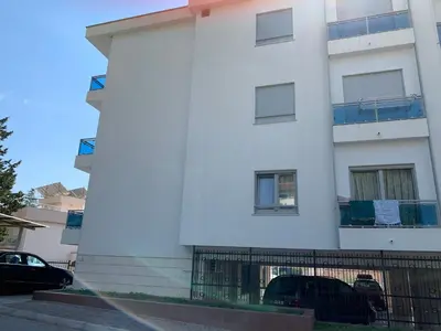 a white building with cars parked in front of it at Njaro del mar 1 in Petrovac na Moru