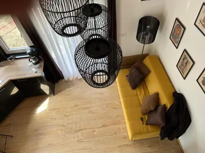 a living room with a yellow couch and a chandelier at M&M Apartments in Kotor