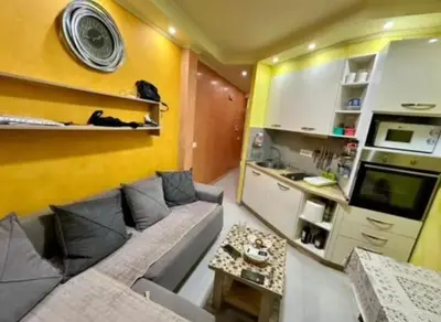 a small living room with a couch and a kitchen at Šušanj Bar in Bar, Susanj