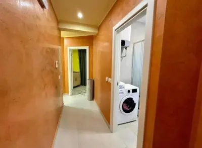 a hallway with a washing machine in a room at Šušanj Bar in Bar, Susanj