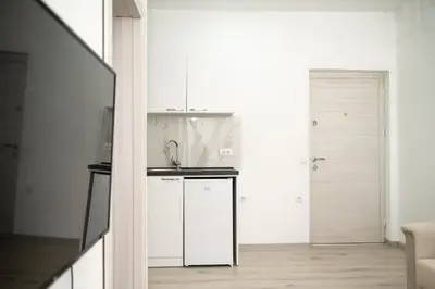 a kitchen with white cabinets and a sink at Rine Apartments in Ulcinj