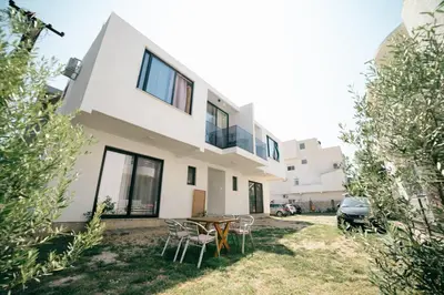 a house with a table and chairs in the yard at Rine Apartments in Ulcinj