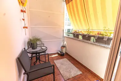 a small balcony with a table and a window with plants at Vukotic in Budva